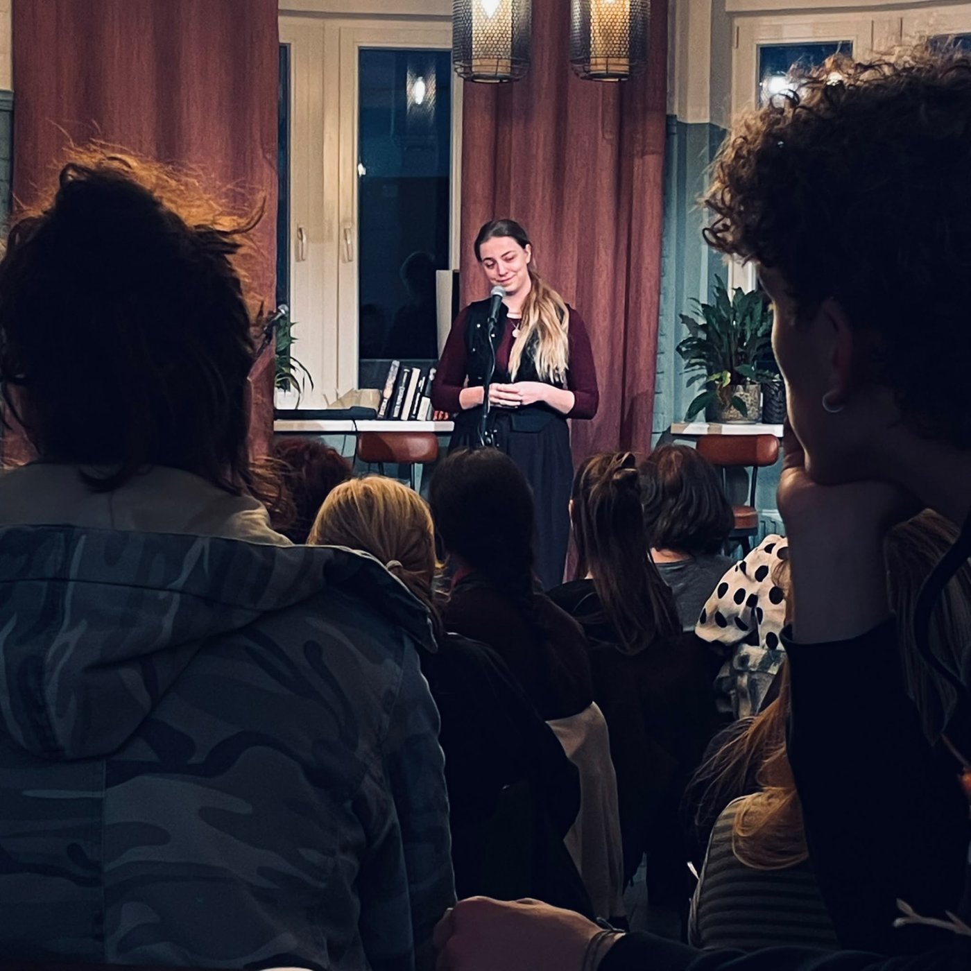 Maturantka přednáší vlastní báseň na večeru slam poetry v Kavárně U kina v Tišnově